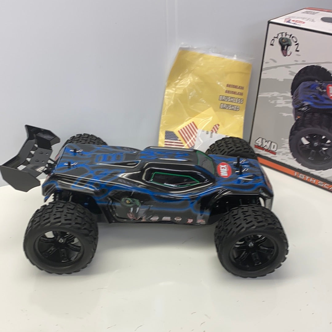 Black and blue remote-controlled truggy with large off-road tires for IMEX 22005, rear view