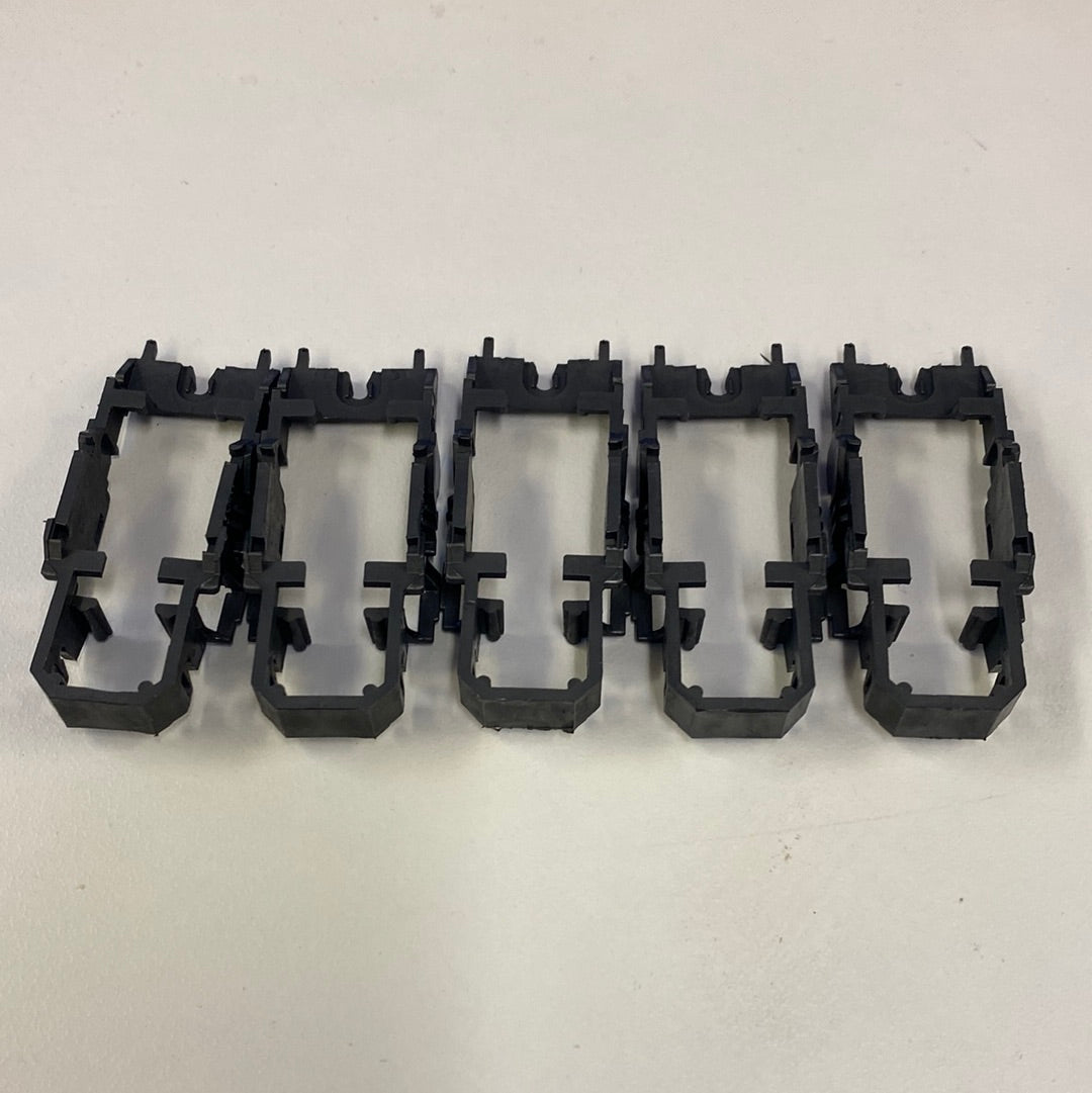 Five black chassis frames for vehicle wiring, laid out horizontally for Tyco H4011