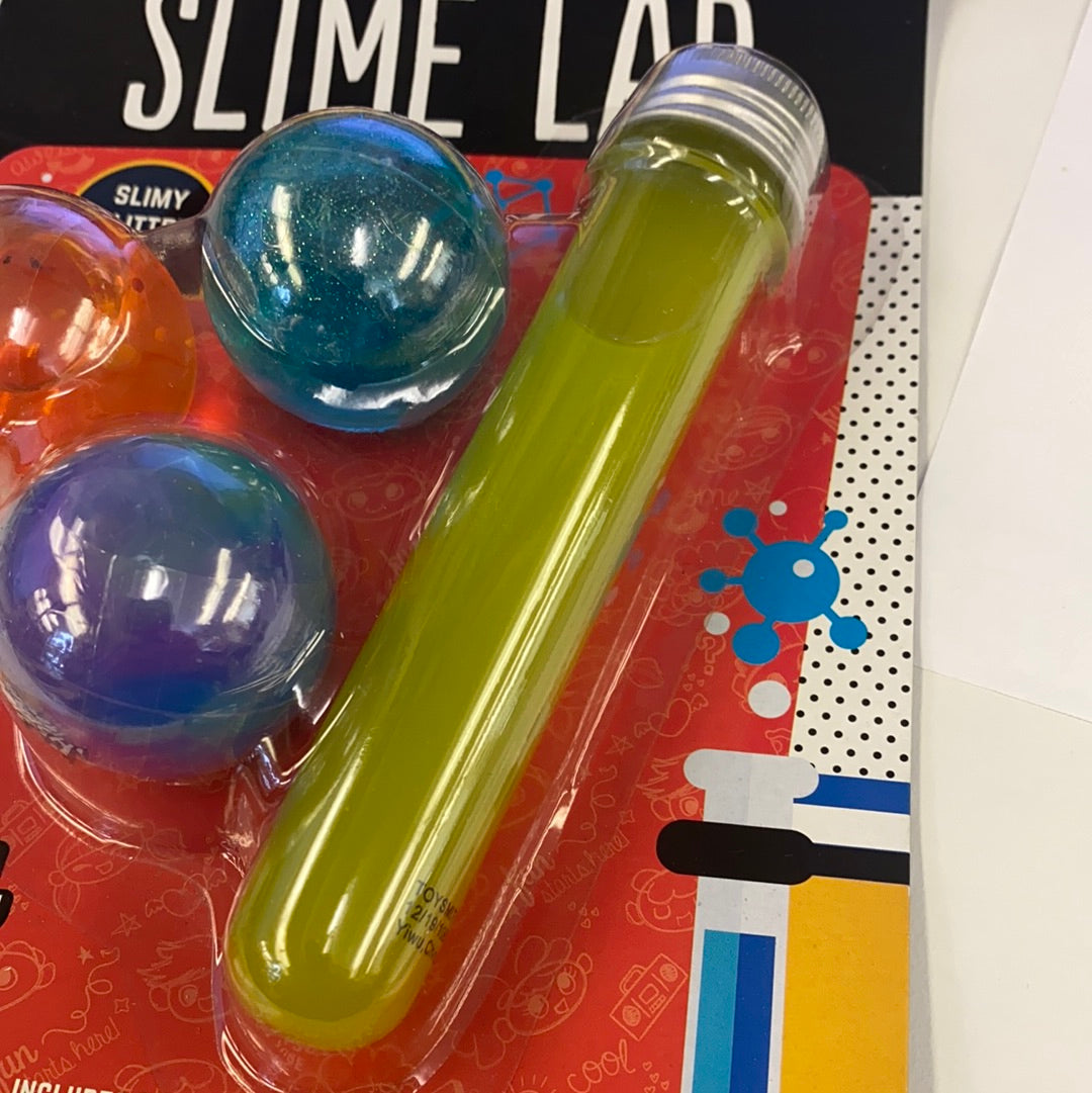 Yellow liquid in a clear plastic bottle next to colorful slime balls for Toy Smith 90979