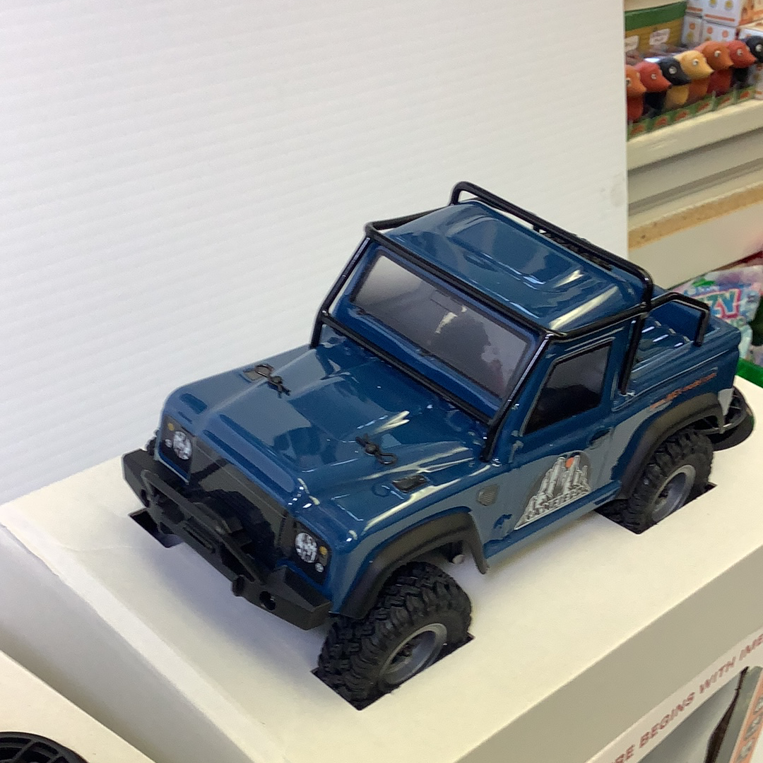 Blue scale crawler vehicle with off-road tires on a white surface for IMX IMX25050