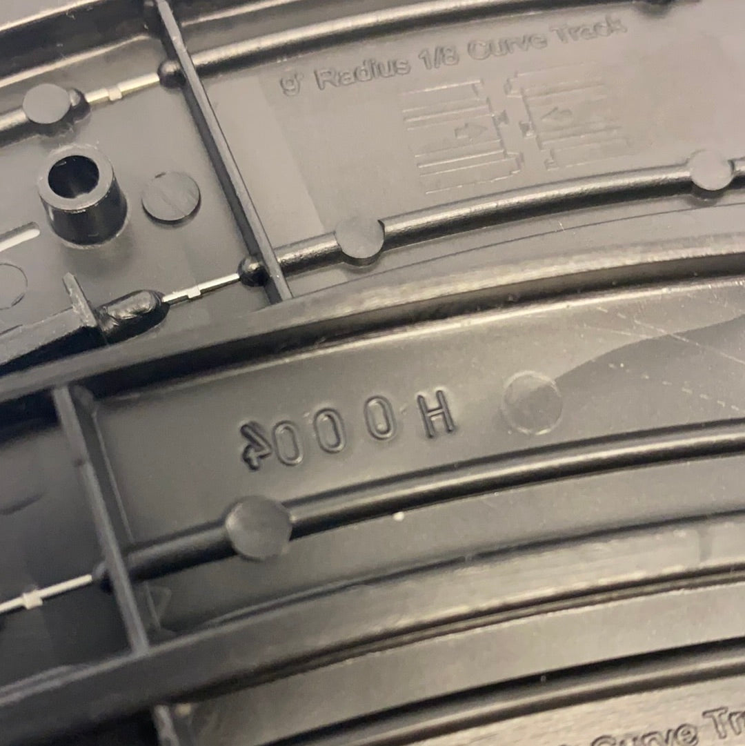 Black model train track section with "9" Radius 1/8 Curve Track" marking for Auto World H0004