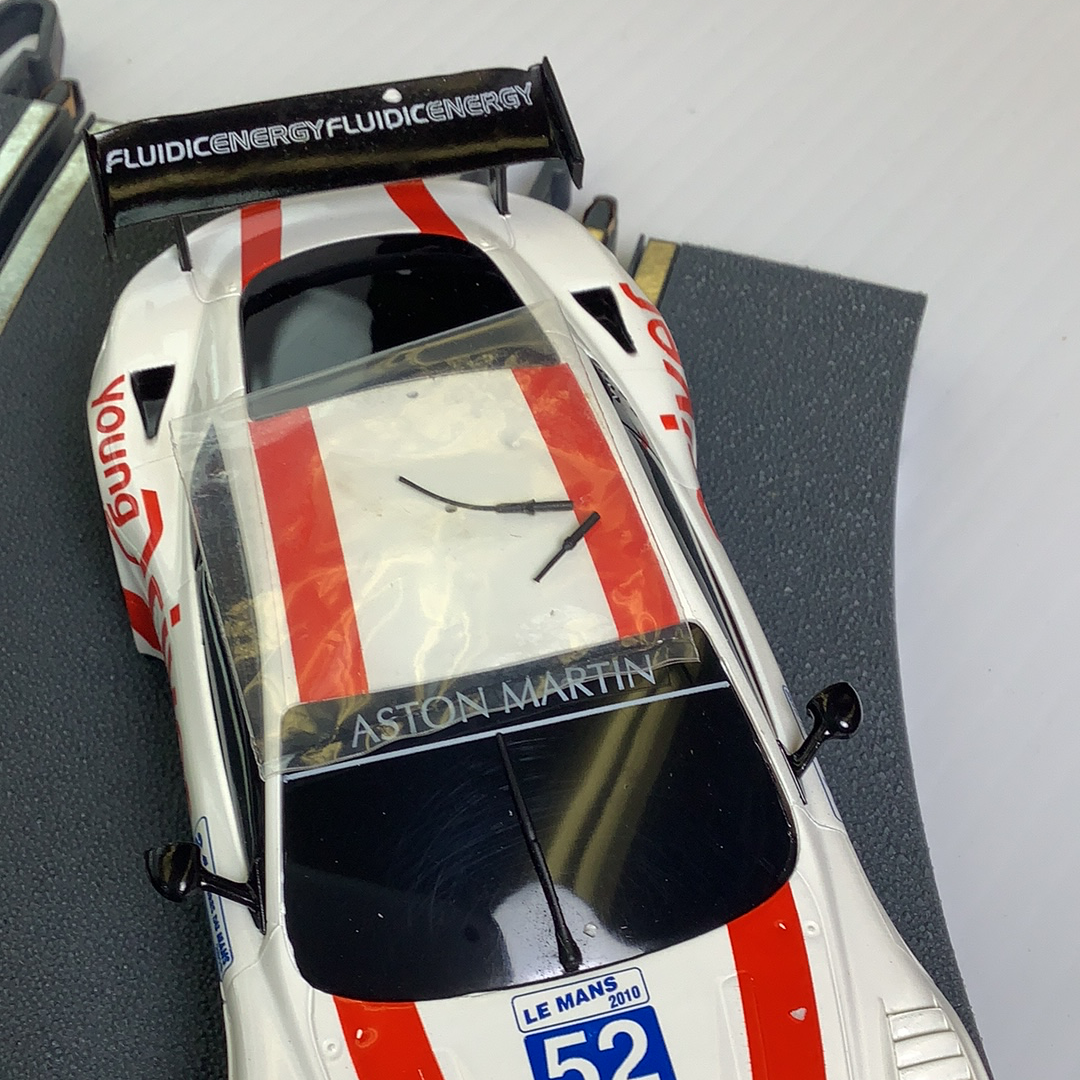 White race car model with red and white stripes, featuring "Aston Martin" script for SCX A10304X3U0