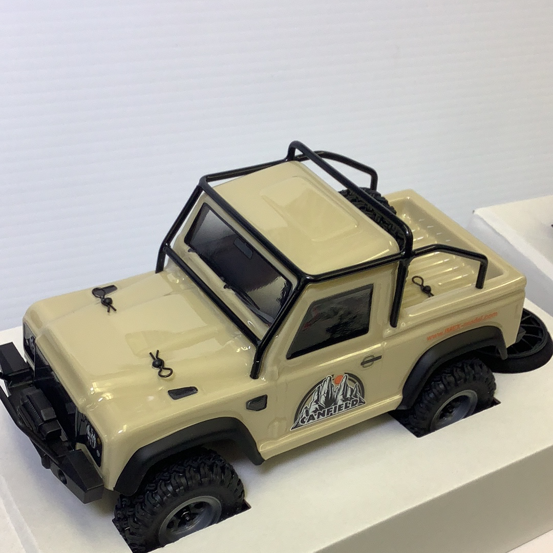 Scale crawler vehicle with black roll cage and off-road tires for IMX IMX25050