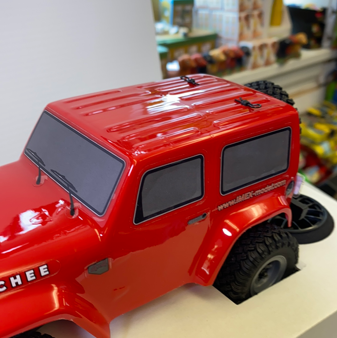 Red scale model crawler vehicle with black windows and knobby tires for IMX IMX25055