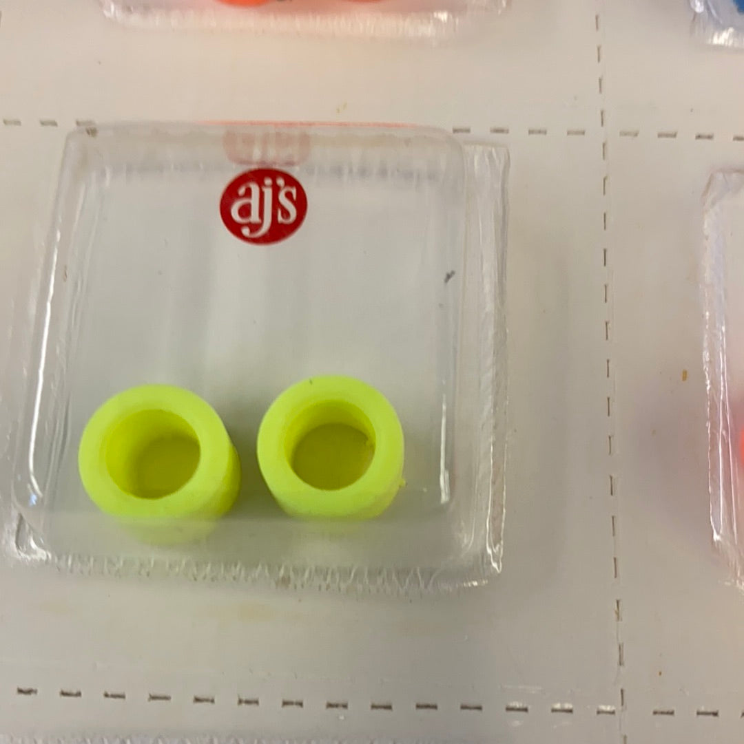 Two bright yellow silicone tire fittings in a clear plastic container for AJ's 002