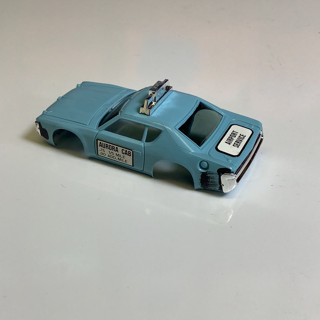 Blue toy taxi cab with "Airport Service" lettering on the side for Aurora / AFX / Tomy B1939B, rear view