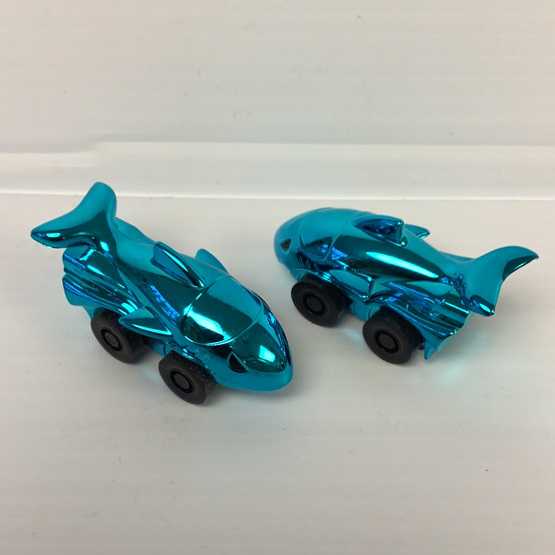 Two shiny, blue toy shark cars on a white surface for California Creations 20870, front view