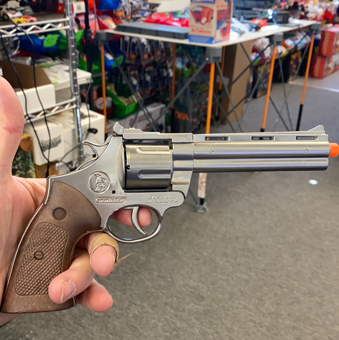 Silver toy revolver held in hand against a blurred background for Gonher 123/0