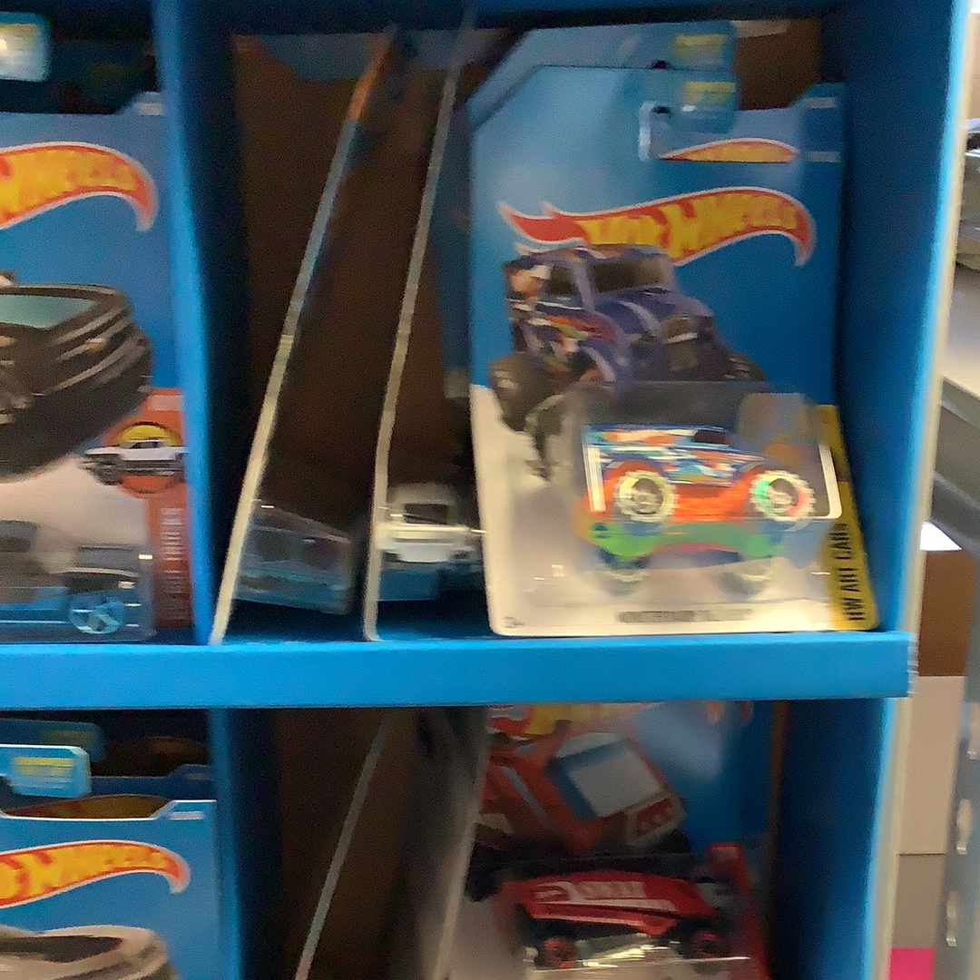 Assorted Hot Wheels cars displayed on blue shelving for UPD FDY58-K910 l Assorted, front view