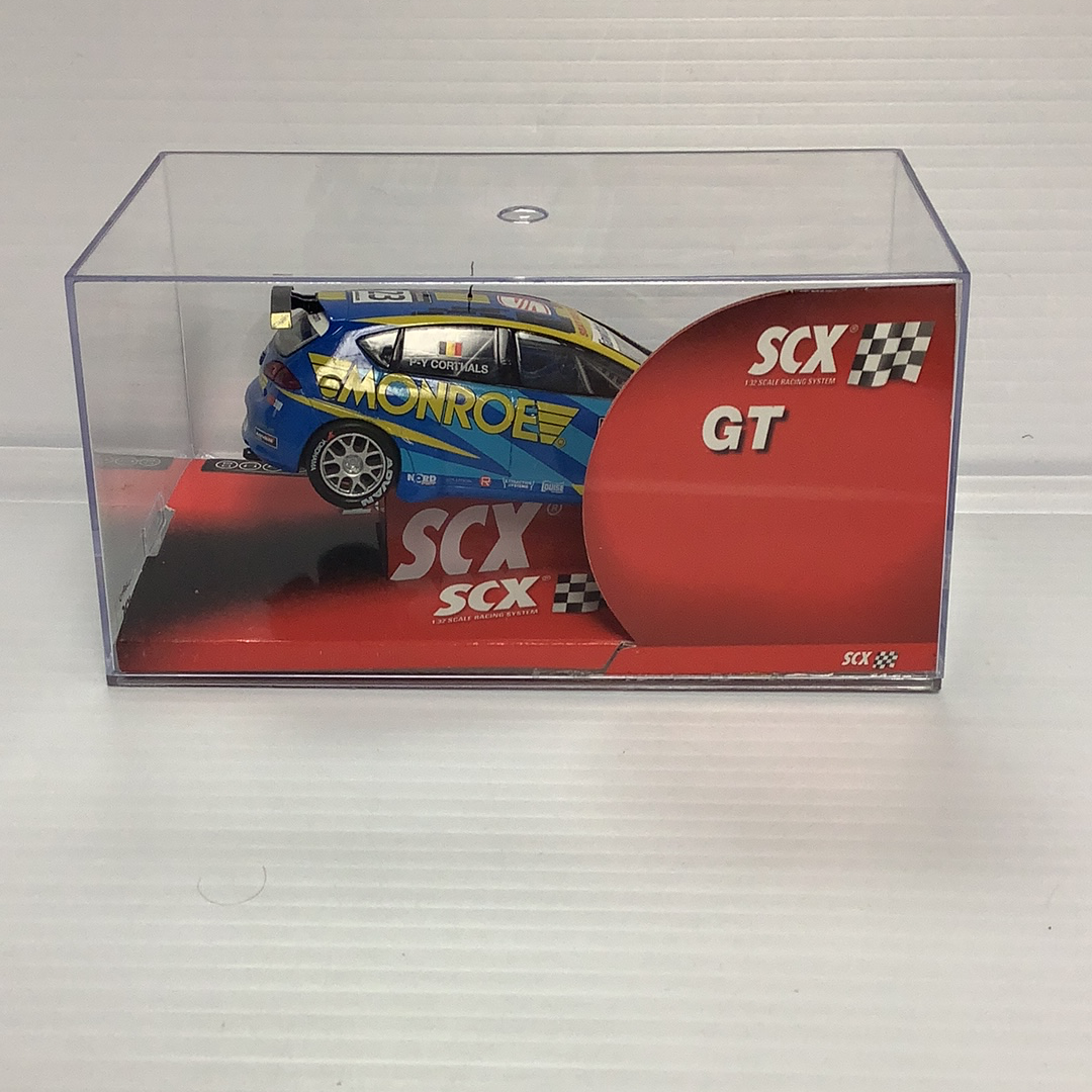 Slot car in clear box: blue and yellow race car with "Corthals" and "GT" branding for SCX 63100