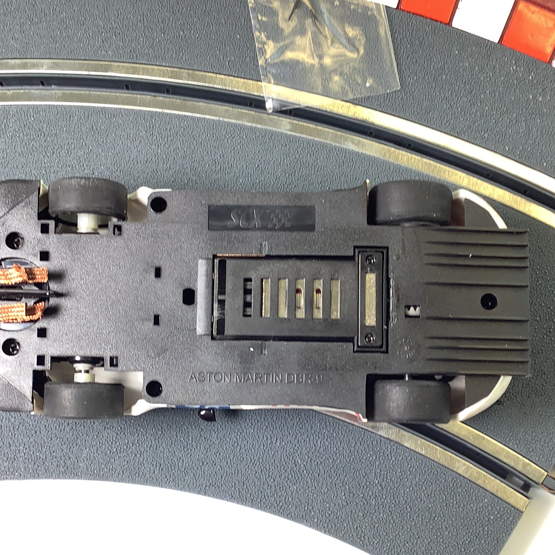 Top view of a slot car Aston Martin DBR9 model car on a track for SCX A10304X3U0