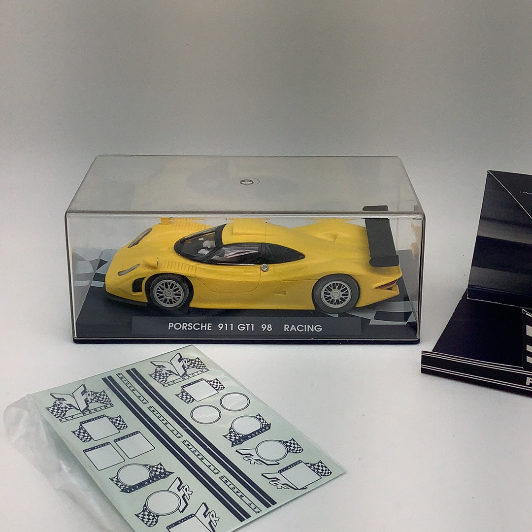 Yellow slot car in clear box with racing decals for Fly Car RG 0a