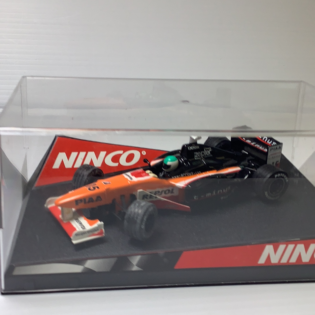 Orange and black race car model on a display base for Ninco 50212