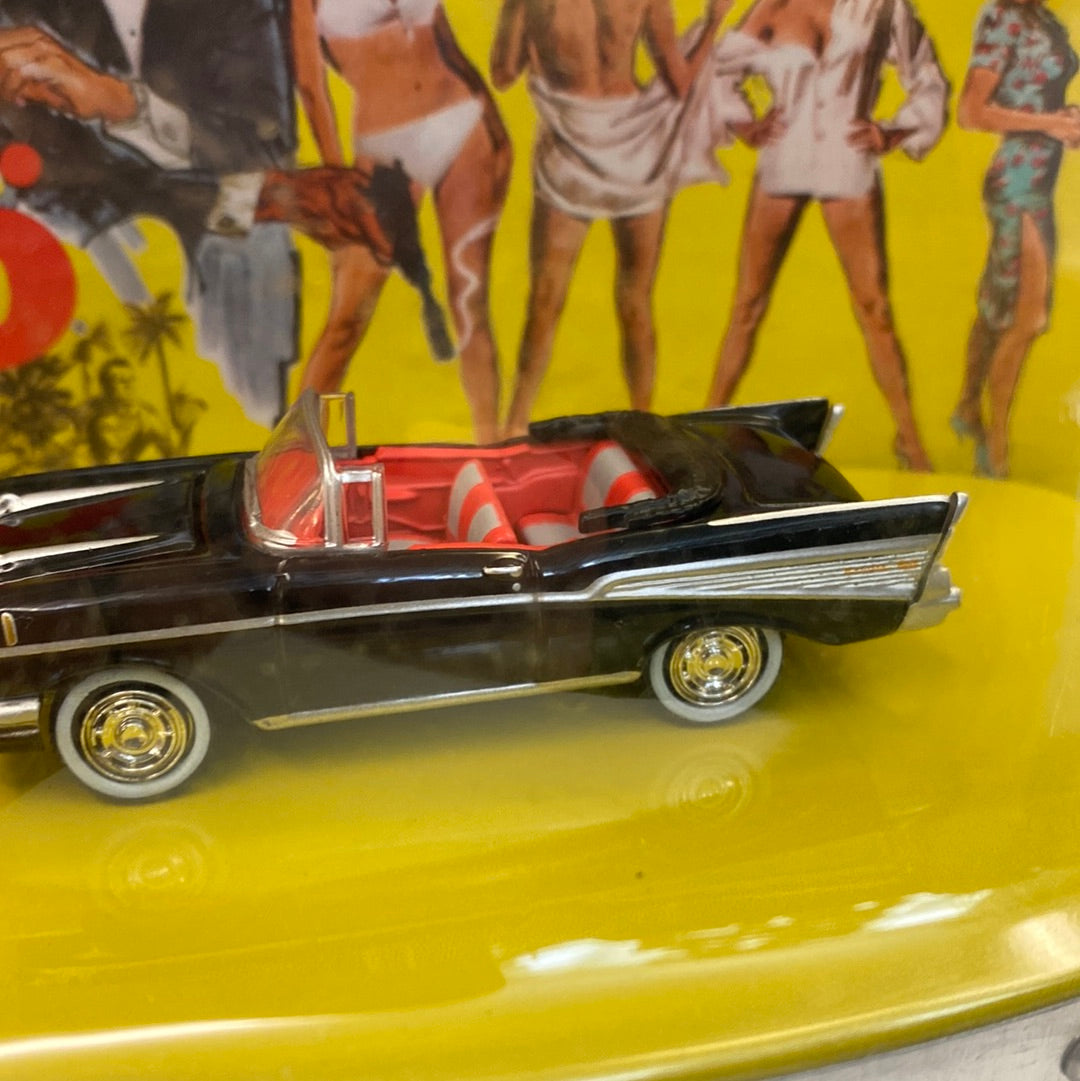 Black 1957 Bel Air convertible toy car on a yellow background for Johnny Lightning JLDR013