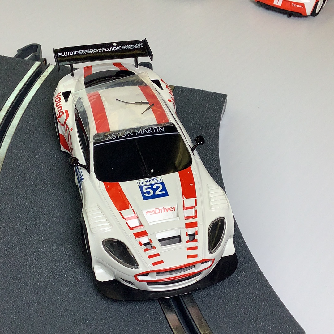 White and red Aston Martin race car model on a track for SCX A10304X3U0