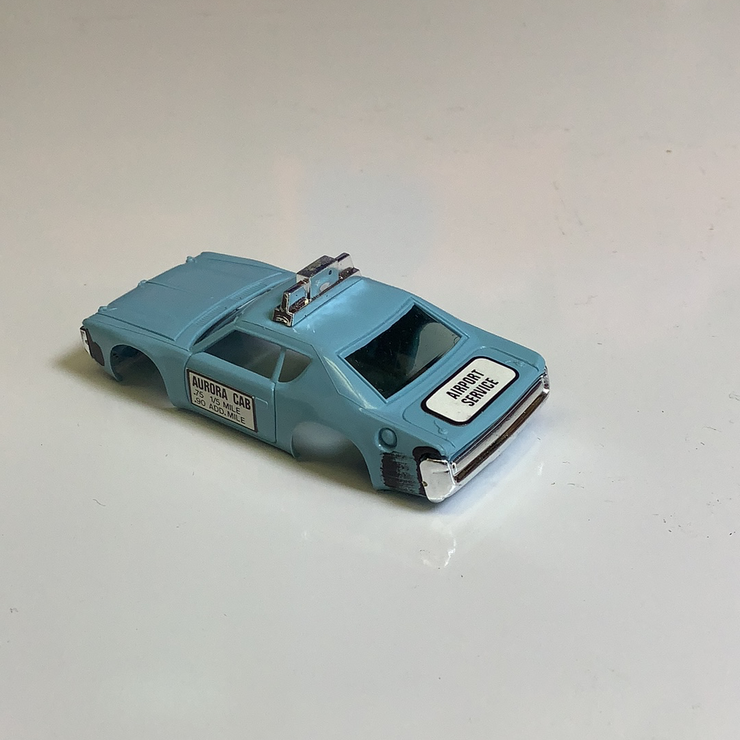 Blue toy taxi cab with "Airport Service" lettering on the side for Aurora / AFX / Tomy B1939B, side view