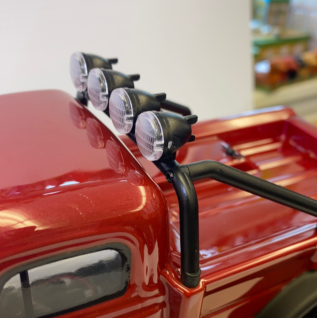 Spotlight array mounted on the hood of a red vehicle for IMX IMX25010