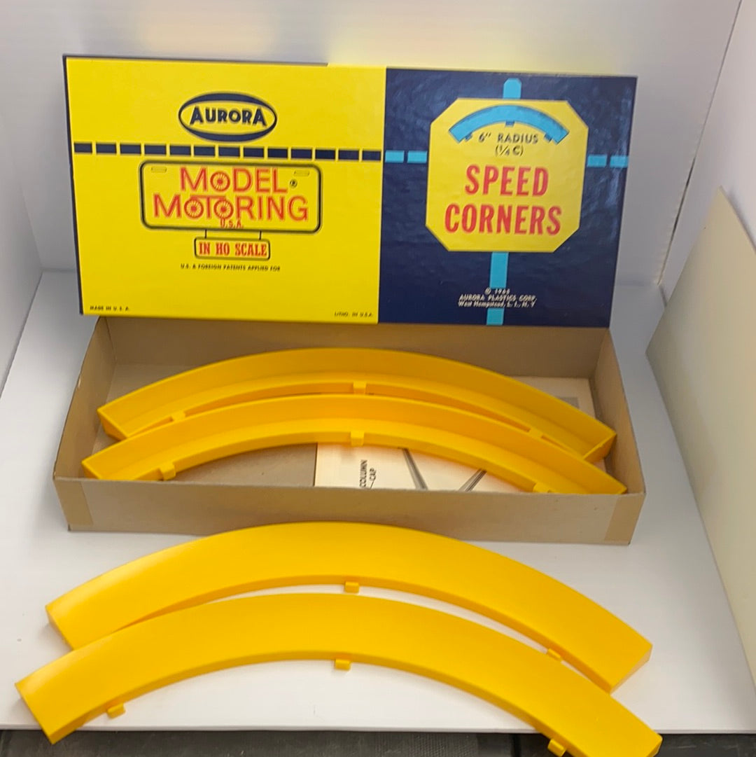 Yellow model train speed corner track pieces in a box for Aurora Model Motoring 1598
