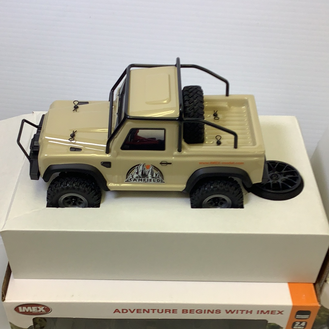 Scale crawler vehicle with tan and black accents on a white surface for IMX IMX25050