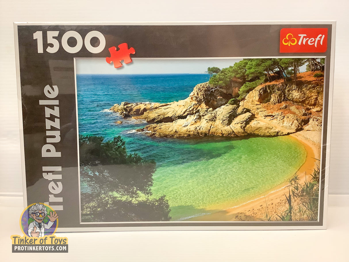 Coastal scene with rocky outcroppings meeting a sandy bay under blue sky for Trefl TRF26091