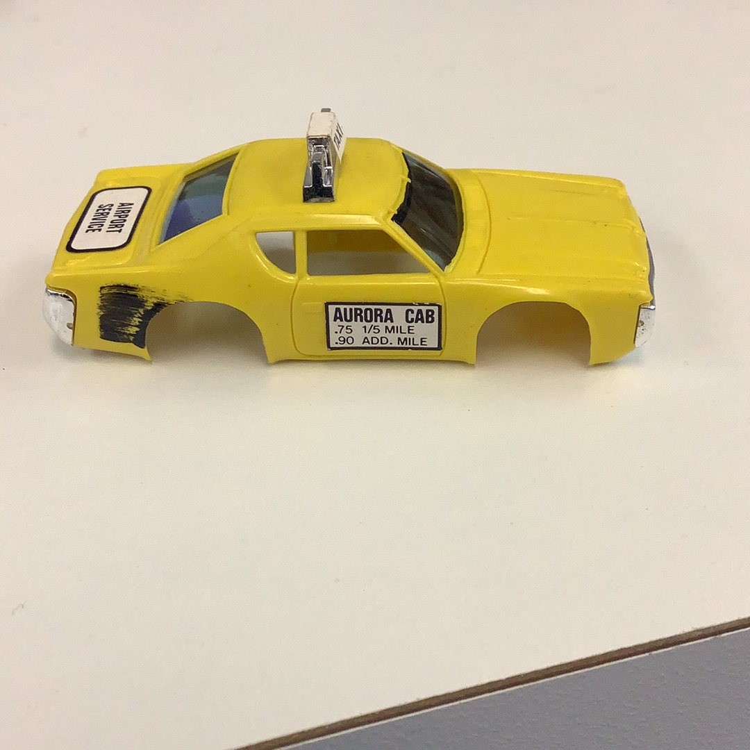 Yellow toy taxi cab with "AURORA CAB" text on the side for Aurora / AFX / Tomy B1939Y