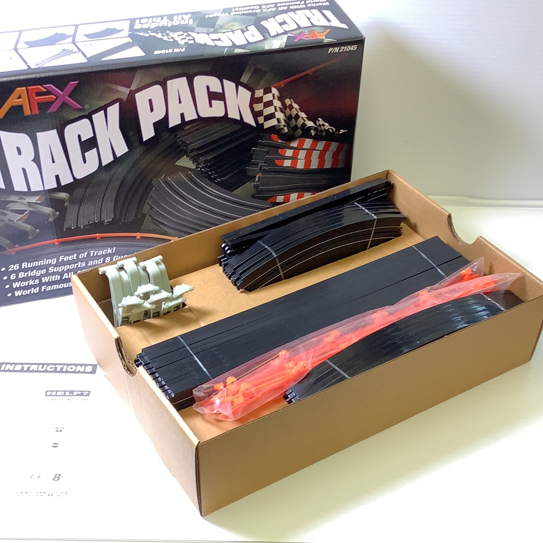 Model railroad track and accessory parts in an open box for AFX/Racemaster 21045