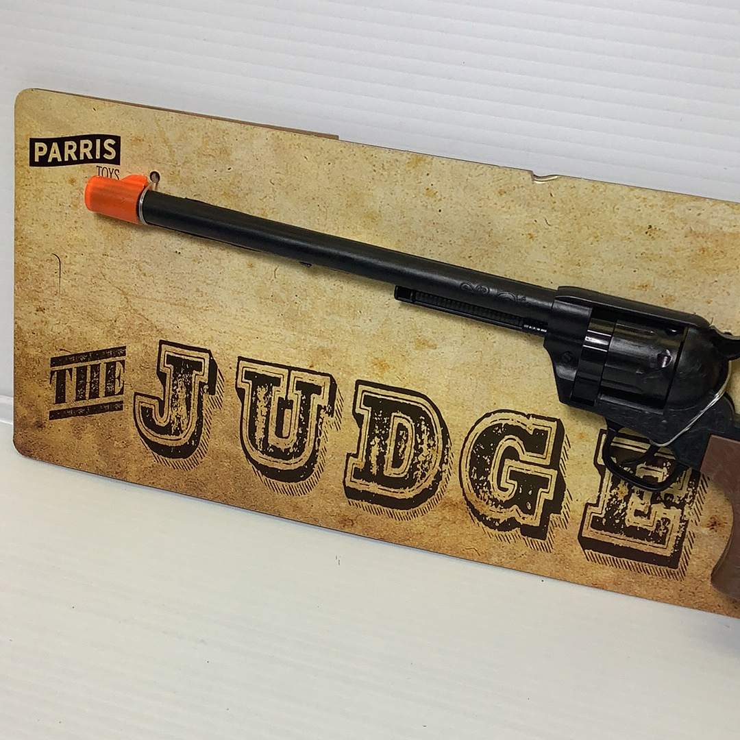 Toy rifle on a cardboard backing with "THE JUDGE" printed on it for Parris Toys 4731C