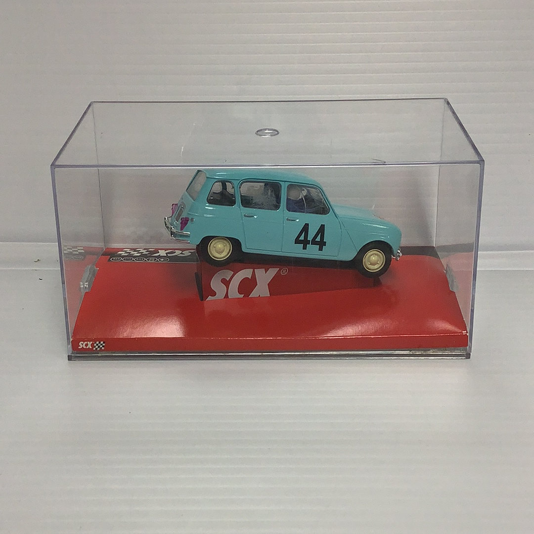 Small blue slot car in a clear display case on a red base for SCX A10070X3U0