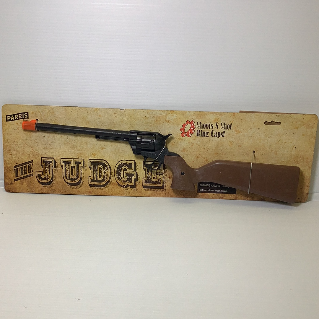 Toy rifle on cardboard backing with "JUDGE" lettering for Parris Toys 4731C