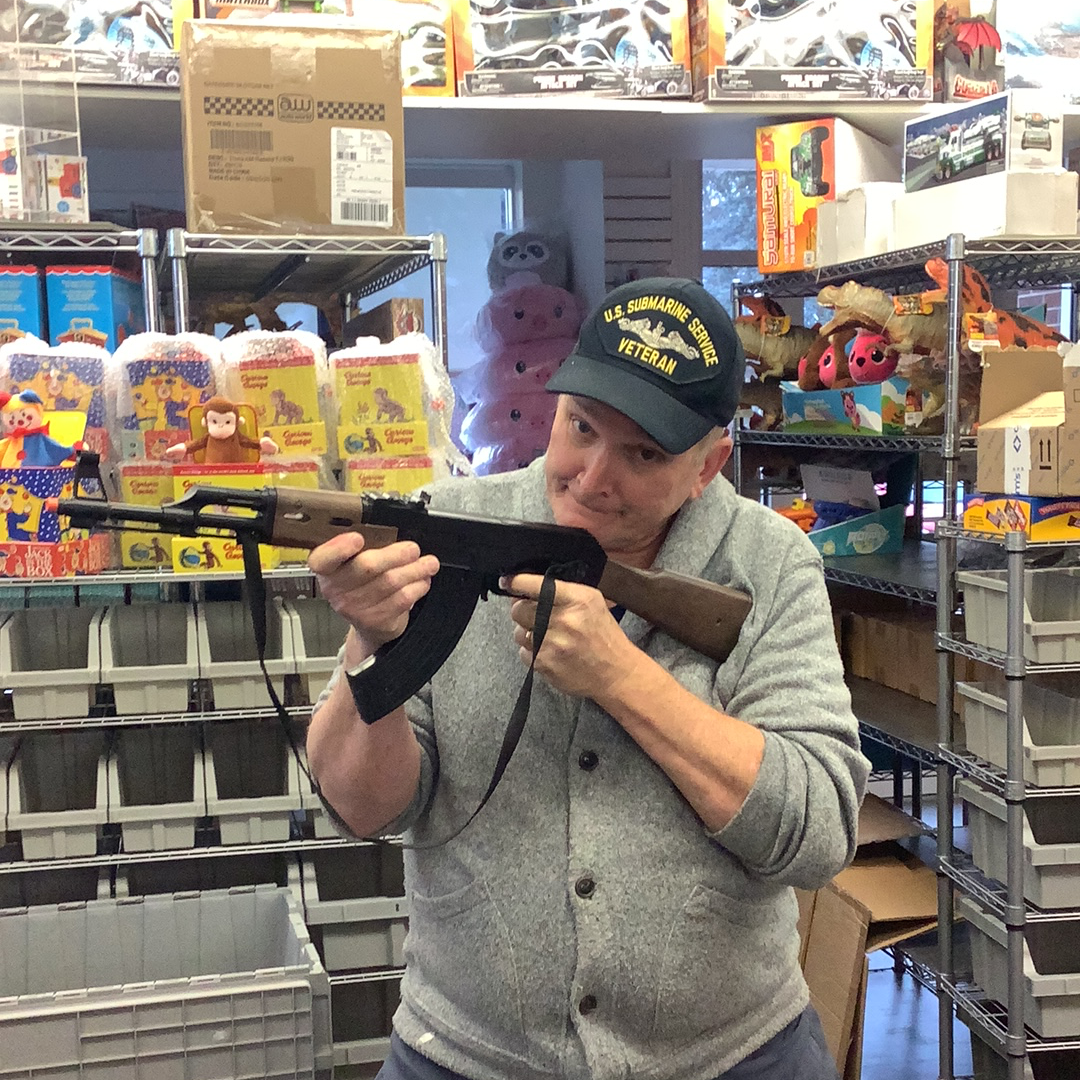 Man holding an AK-47 assault rifle in a store aisle for Gonher 1135/6, front view