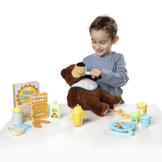 Child plays with a bear toy and meal set, including pretend food and dishes for Melissa and Doug 31708