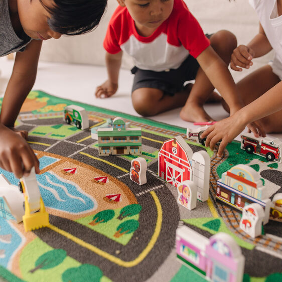 Kids play with toy vehicles on a colorful Paw Patrol activity rug for Melissa and Doug 33273, front view