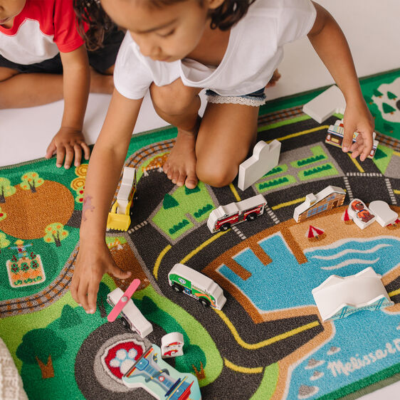 Kids play with toy vehicles on a colorful Paw Patrol activity rug for Melissa and Doug 33273, rear view