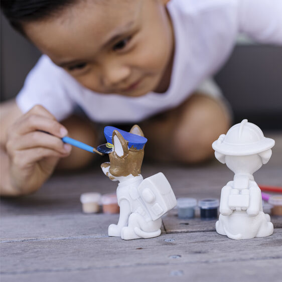 Child paints pup figurines on a wooden surface for Melissa and Doug 33265