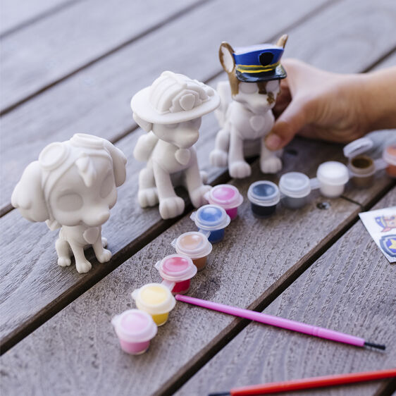 White pup figurines and craft supplies on a wooden surface for Melissa and Doug 33265