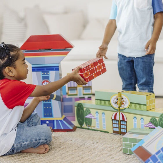 Child plays with colorful, stackable cardboard building blocks indoors for Melissa and Doug 33277