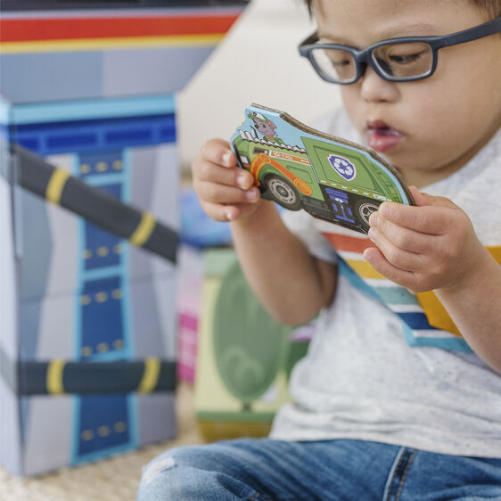Child examines a toy vehicle near large, colorful cardboard blocks for Melissa and Doug 33277