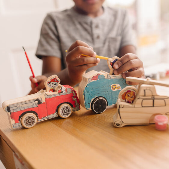 Child crafts wooden Paw Patrol vehicles on a table for Melissa and Doug 33266