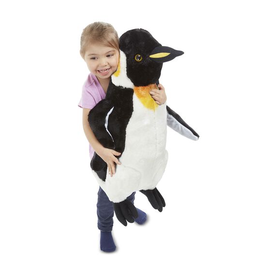 Child hugging a black and white plush penguin toy for Melissa and Doug 2122