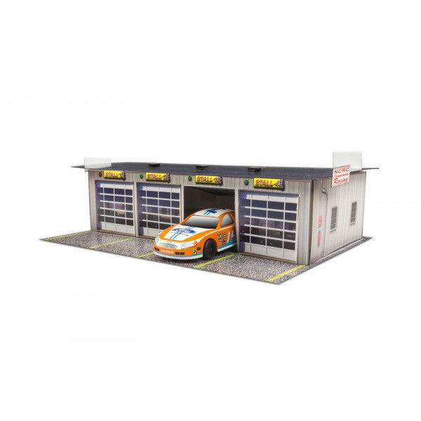 Model kit of a pit garage with a race car parked outside for Innovative Hobby Supply BK3211