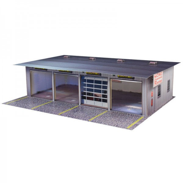 Model kit of a pit garage with multiple bays and a gravel foreground for Innovative Hobby Supply BK3211