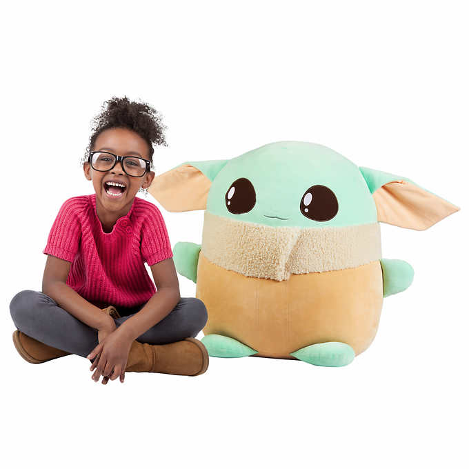 Child with plush Grogu toy, smiling for Star Wars 1566