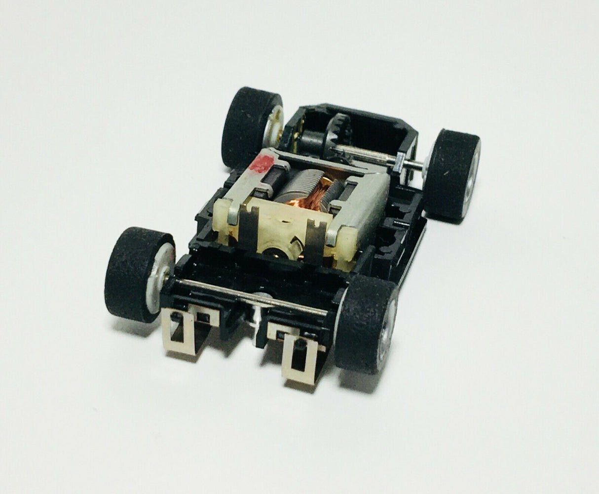 Lighted chassis for model train, showing motors and wheels for Tyco