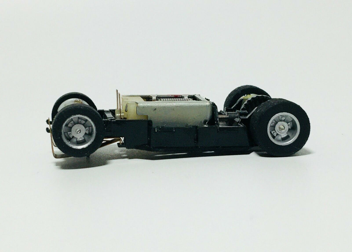 Black and silver toy car chassis with four wheels for Tyco