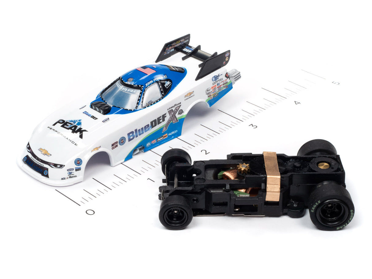 Slot car of a drag racing car and its chassis on a ruler for Auto World SC352, rear view