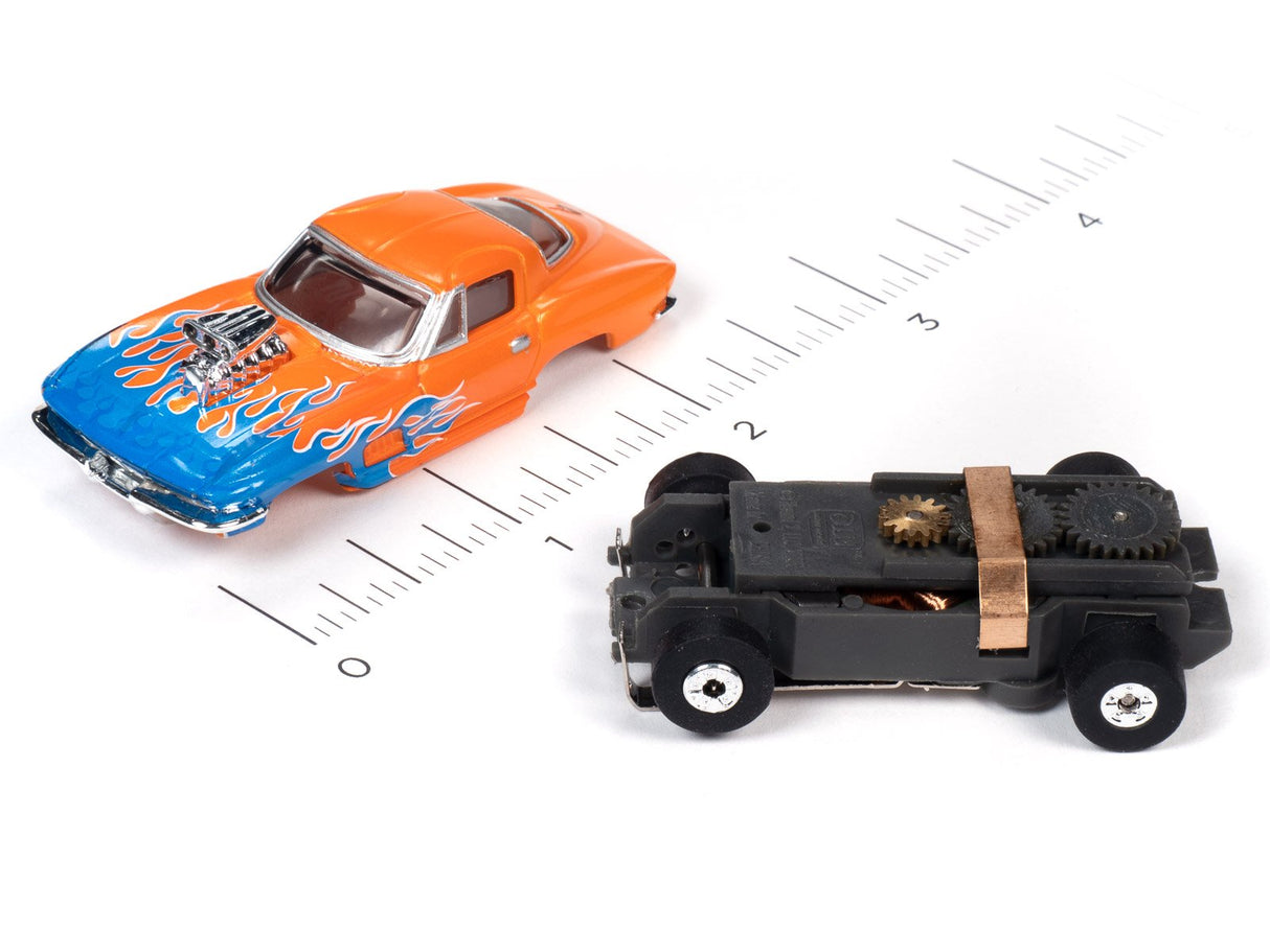 Orange and blue flame car toy next to a black, mechanical toy car on a ruler for Auto World SC353