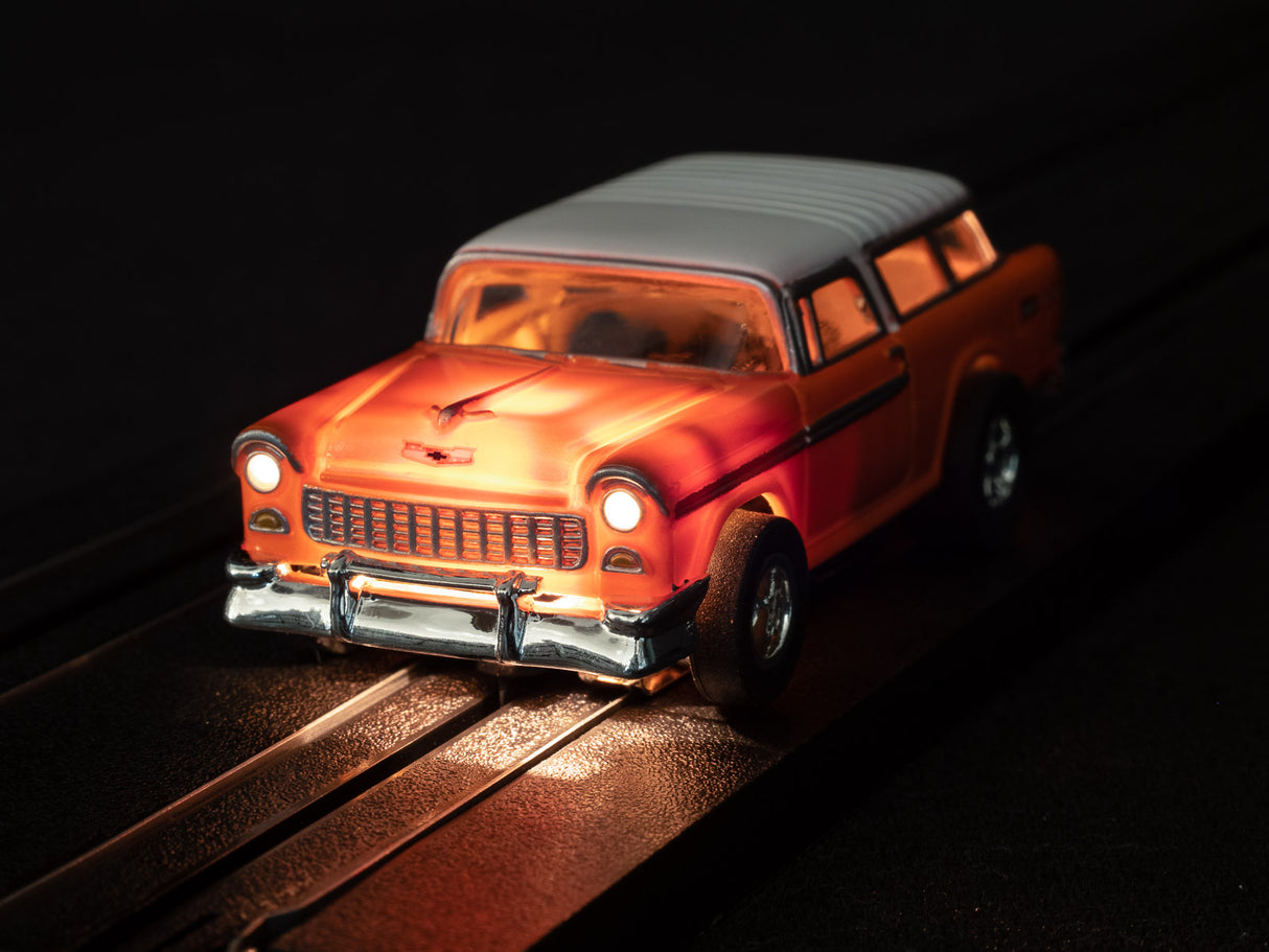 Orange classic car toy on dark tracks with bright headlights for Auto World SC366