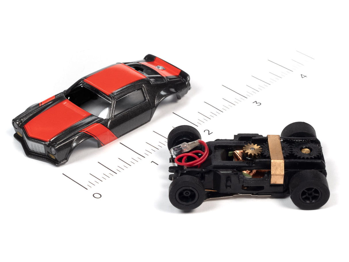 Black and red toy cars on a ruler scale, showing size comparison for Auto World SC366