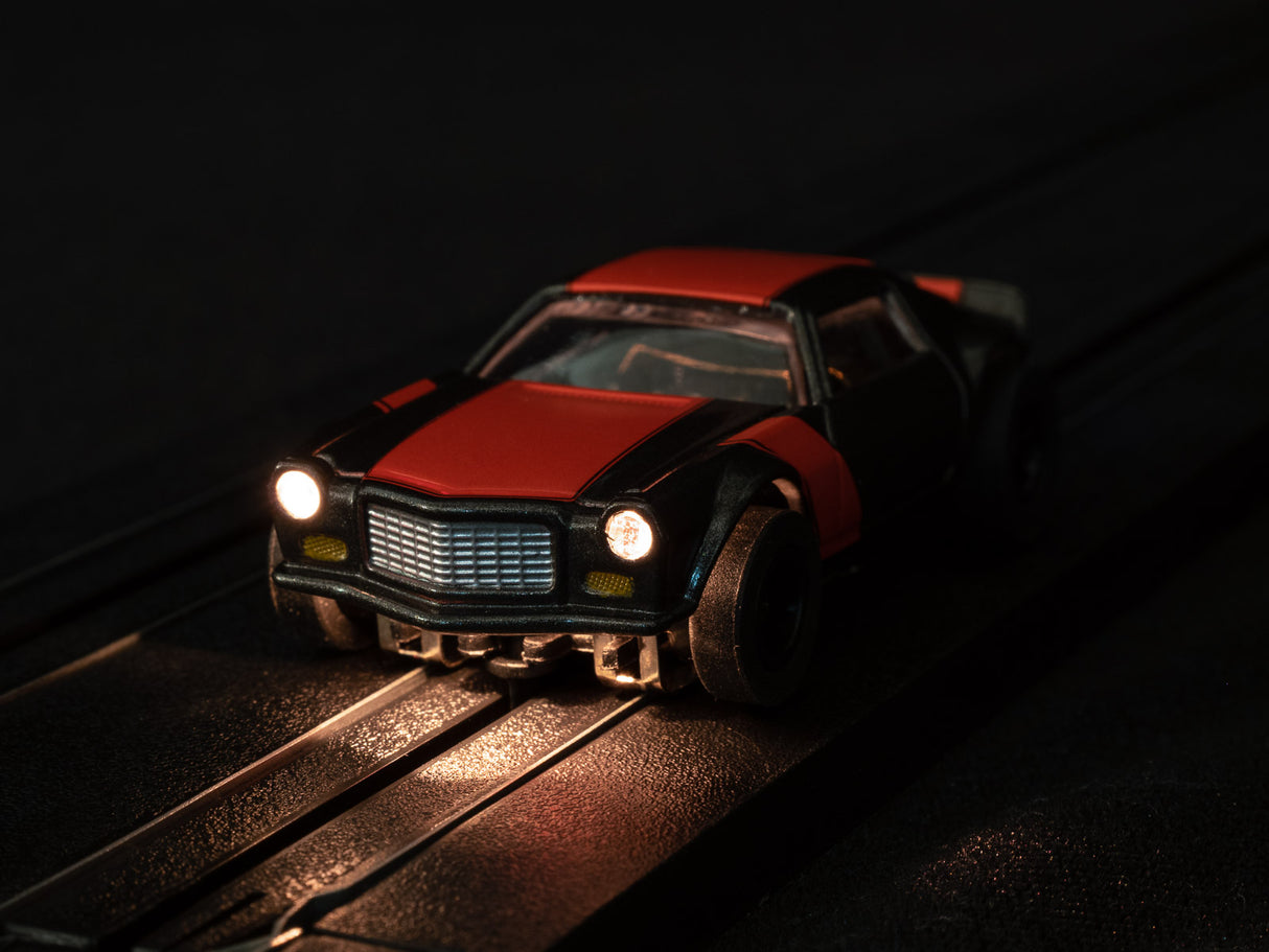 Red slot car on tracks with illuminated headlights for Auto World SC366