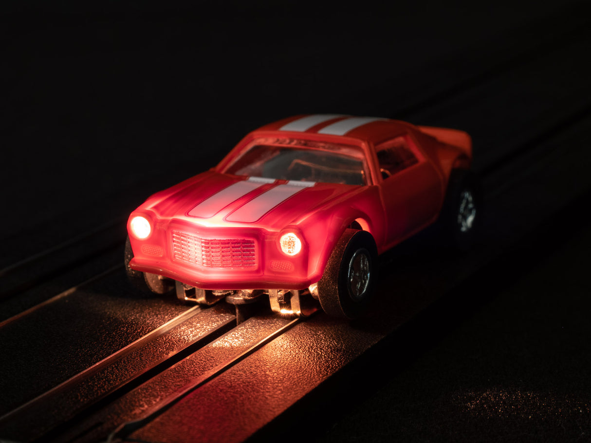Red toy car with flames, positioned on dark tracks for Auto World SC366